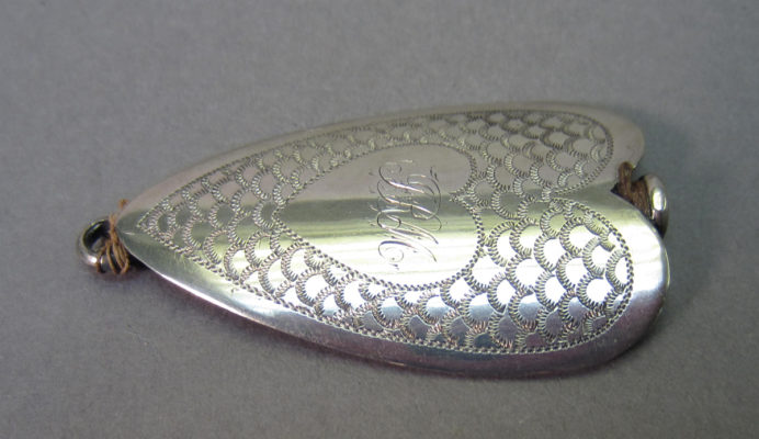 Front of silver needle sheath with inscribed initials
