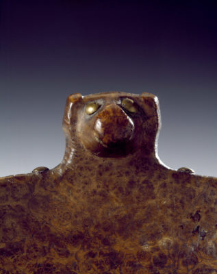 Detail of bear head rising from the top edge of the bowl.